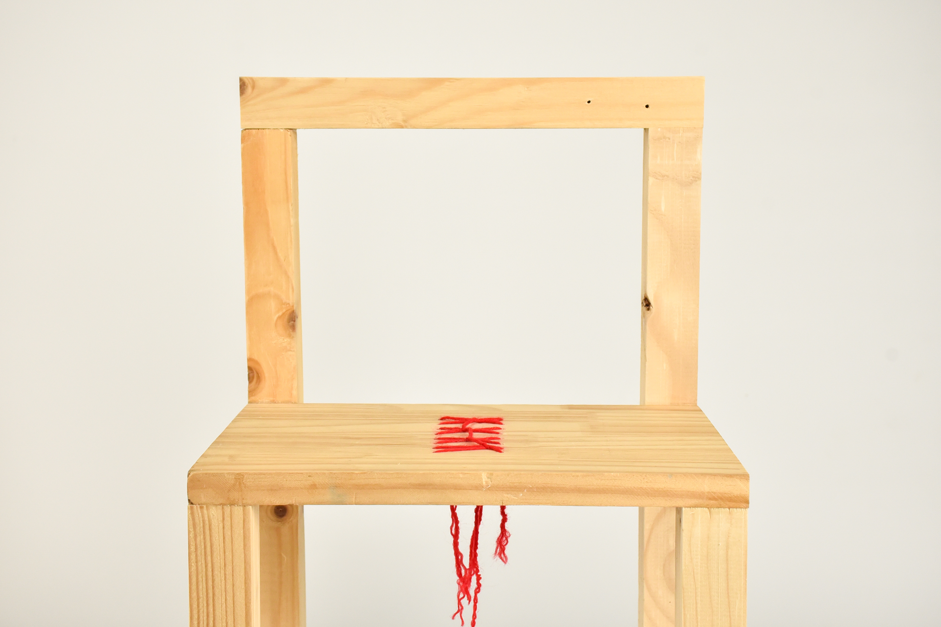 Détail — fil rouge cousu dans l'assise