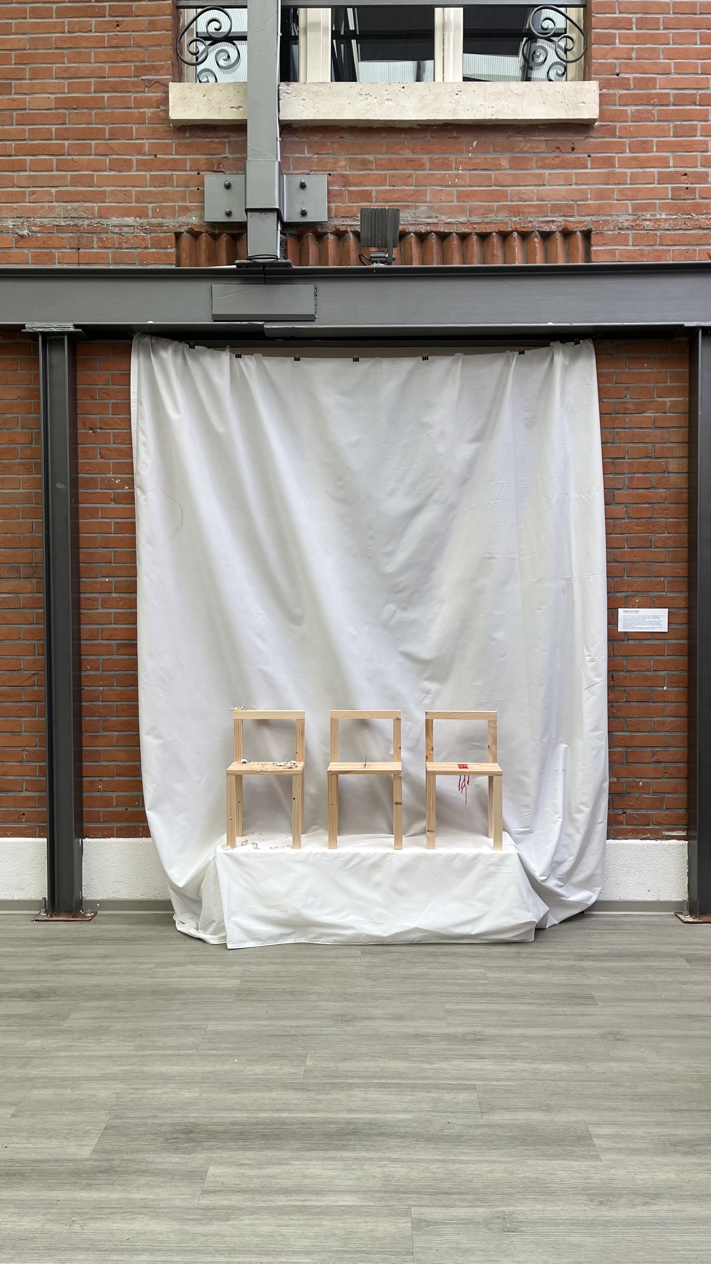 Vue d'ensemble — trois chaises dans l'espace d'exposition
